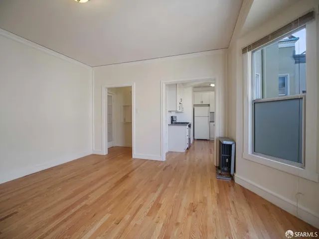 a view of empty room with wooden floor