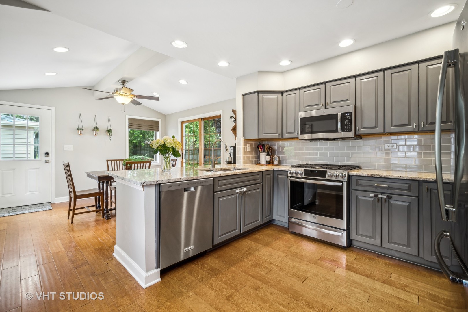 221 West Harrison Road Lombard, IL 60148 - Photo 6 of 24 a kitchen with kitchen island granite countertop a stove top oven a sink dishwasher a dining table and chairs