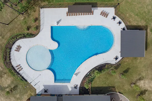 an aerial view of a house with swimming pool and outdoor seating