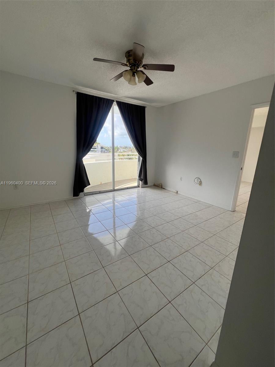 9156 Collins Avenue, Unit 502 Surfside, FL 33154 - Photo 5 of 20 an empty room with windows and ceiling fan
