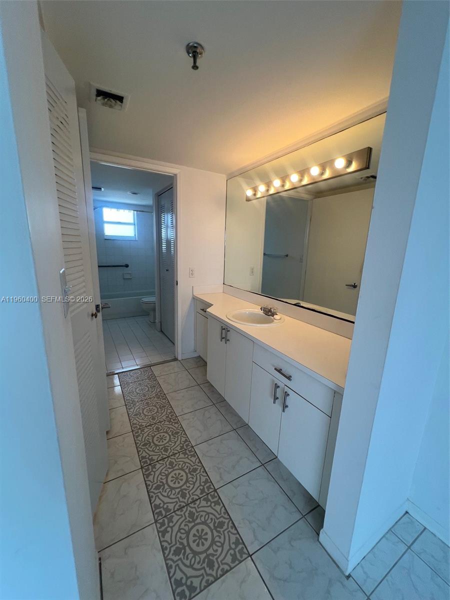 9156 Collins Avenue, Unit 502 Surfside, FL 33154 - Photo 7 of 20 a bathroom with a double vanity sink and mirror