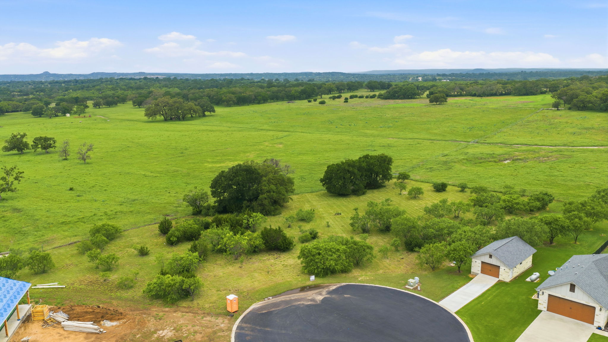 104 Round Up Circle Burnet, TX 78611 - Photo 4 of 23 Expansive green landscape with scattered trees, offering open space