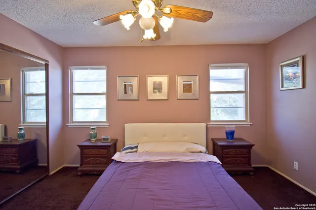 a spacious bedroom with a bed and a chandelier