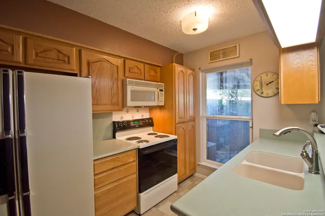 a bathroom with a tub sink and a refrigerator