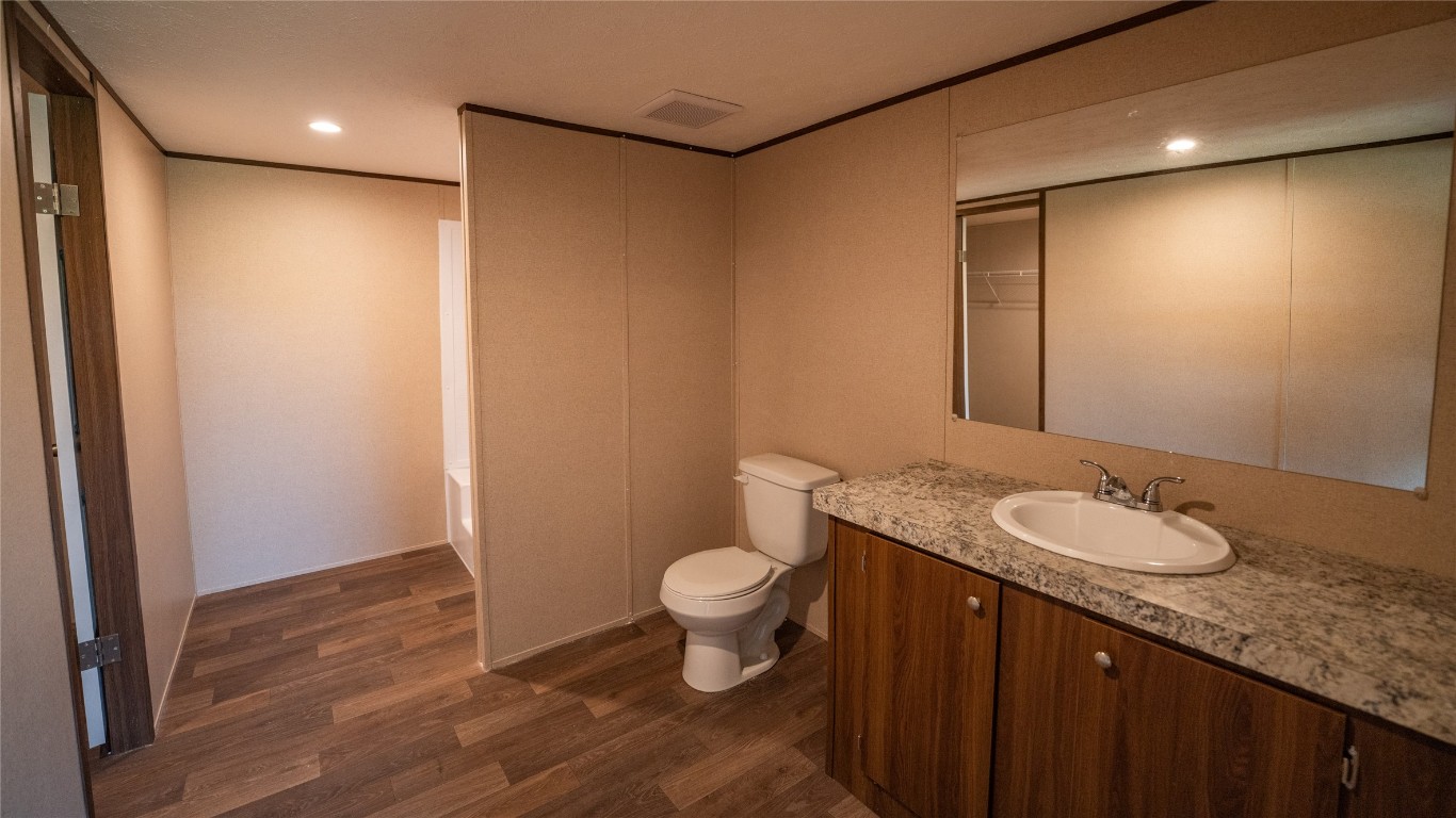 1121 Callihan Road Luling, TX 78648 - Photo 11 of 35 a bathroom with a granite countertop sink a toilet and a mirror
