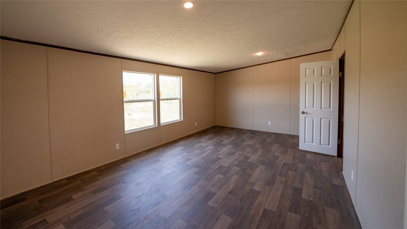 1121 Callihan Road Luling, TX 78648 - Photo 13 of 35 a view of an empty room with wooden floor and a window