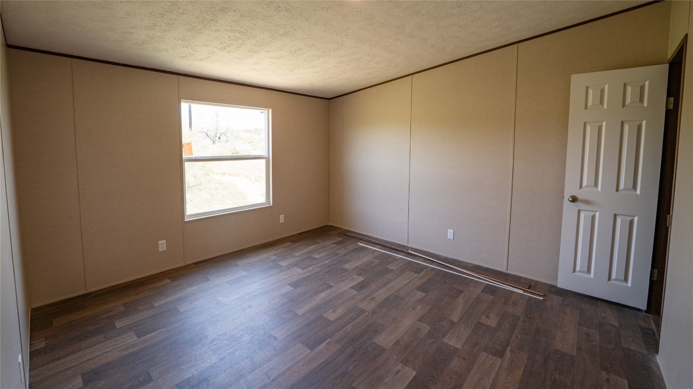 1121 Callihan Road Luling, TX 78648 - Photo 17 of 35 an empty room with wooden floor and windows