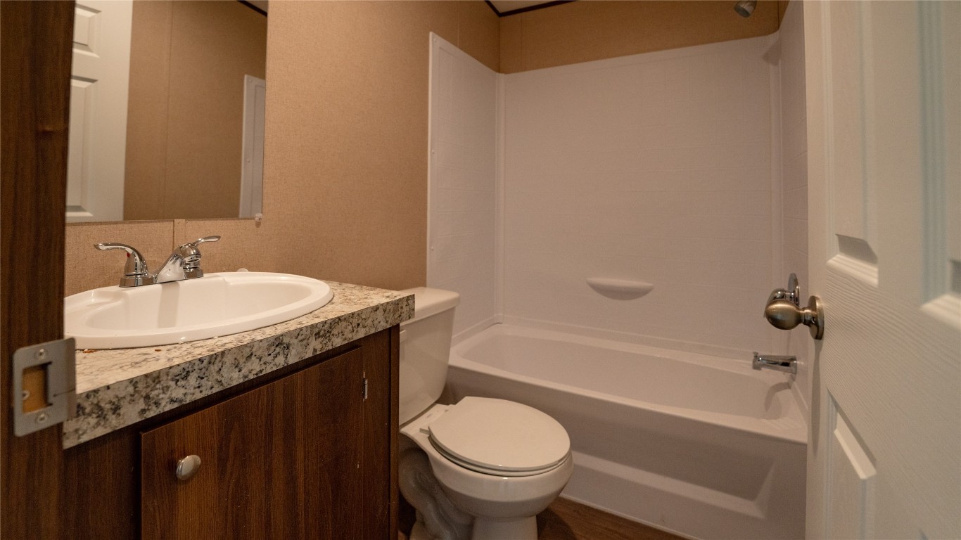 1121 Callihan Road Luling, TX 78648 - Photo 22 of 35 a bathroom with a granite countertop sink toilet and shower