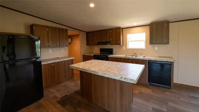 a kitchen with a sink a refrigerator and cabinets