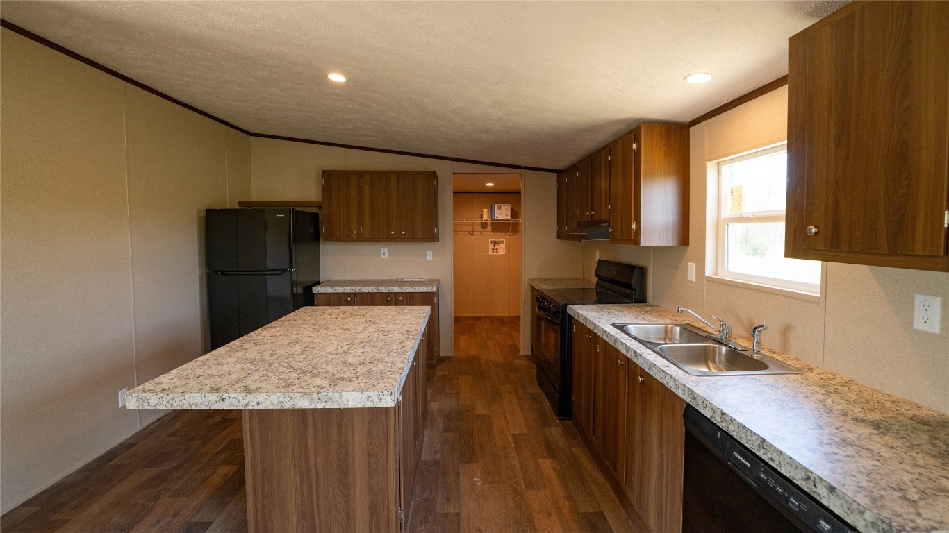 1121 Callihan Road Luling, TX 78648 - Photo 28 of 35 a kitchen with a sink a refrigerator and cabinets