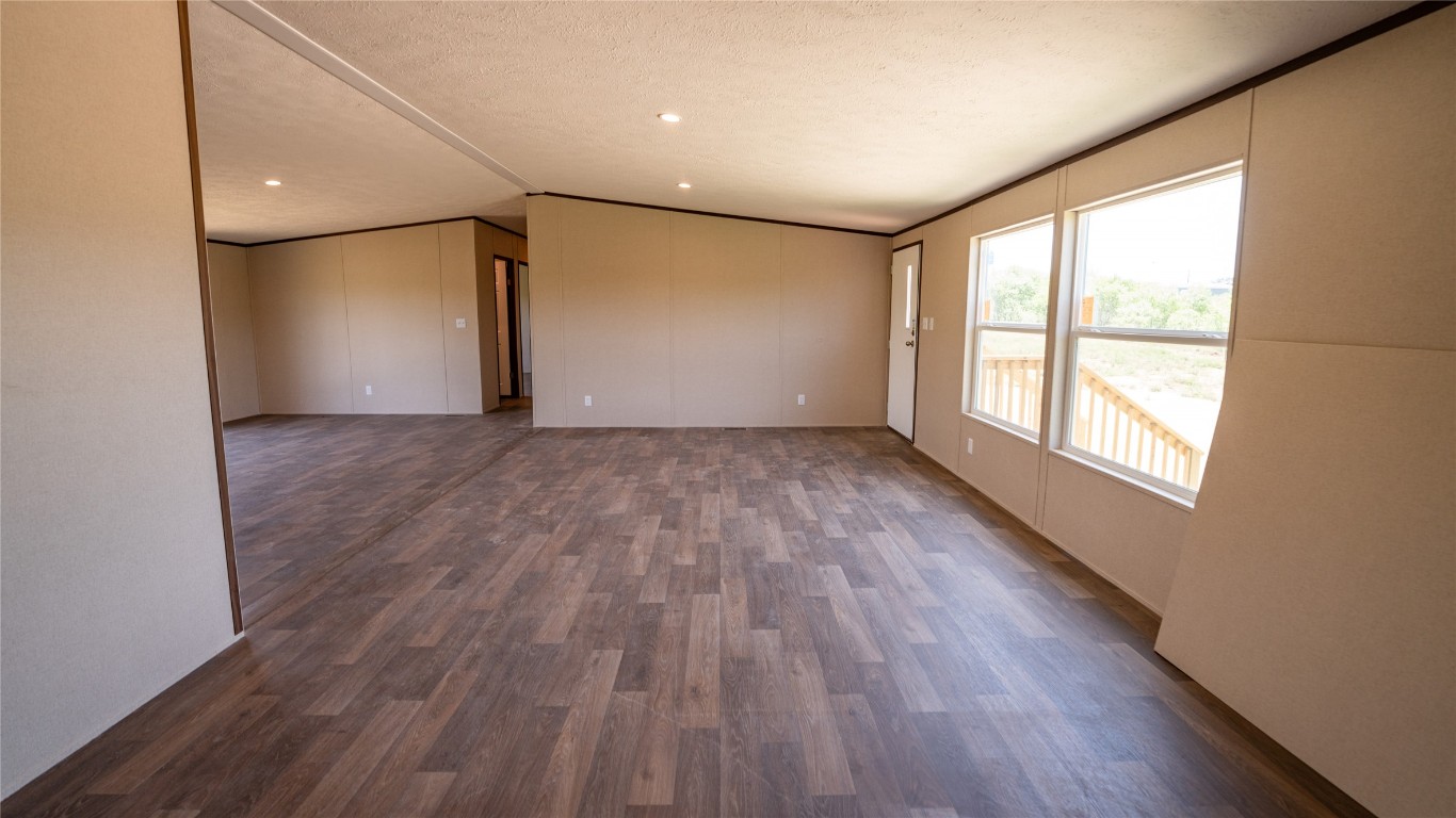 1121 Callihan Road Luling, TX 78648 - Photo 8 of 35 a view of an empty room with wooden floor and a window