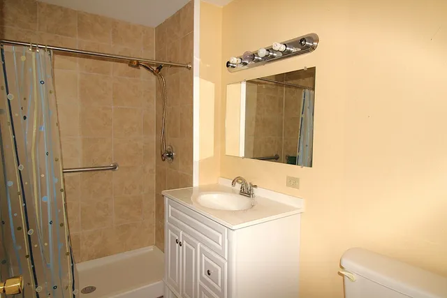 a view of a room with wooden floor and fan