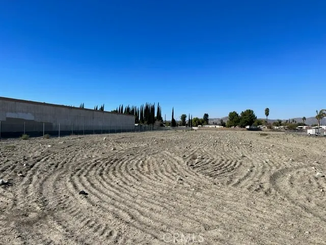 a view of a dry yard with trees