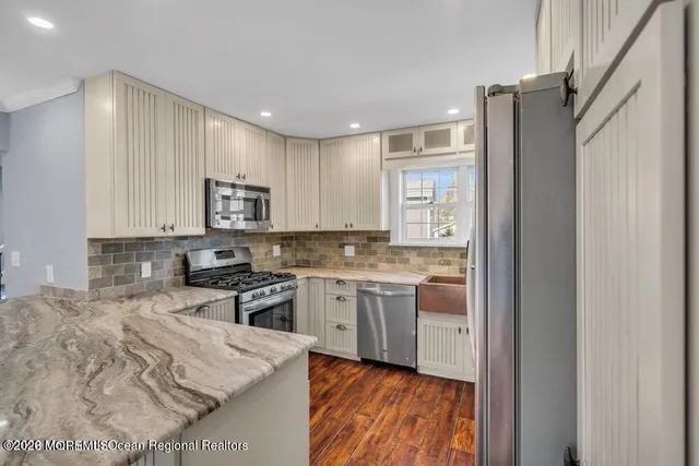 a kitchen with kitchen island granite countertop appliances cabinets and a sink