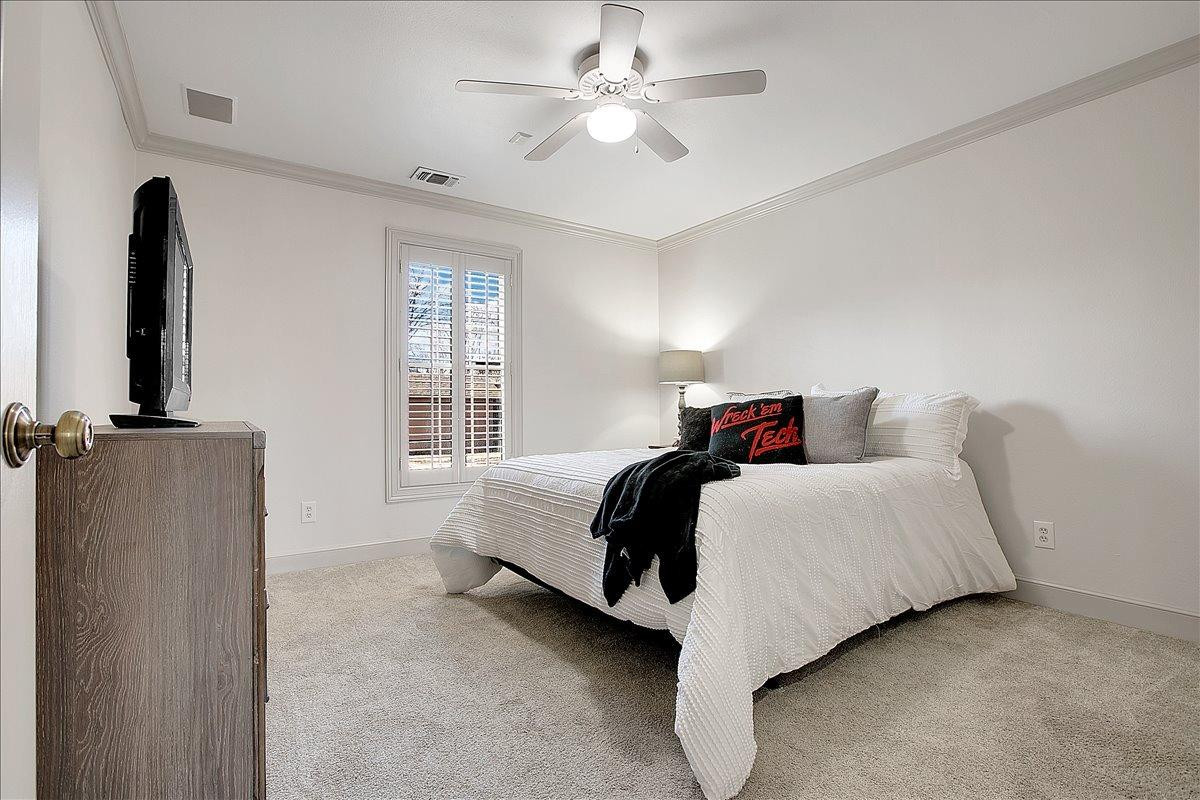 3203 32nd Street Lubbock, TX 79410 - Photo 15 of 27 a bedroom with a bed and a chandelier