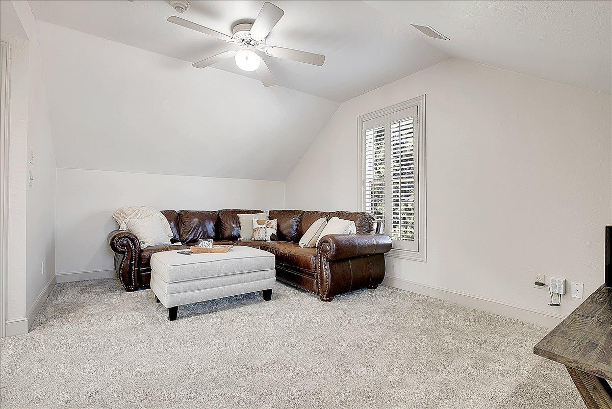 3203 32nd Street Lubbock, TX 79410 - Photo 16 of 27 a spacious bedroom with a bed and a ceiling fan