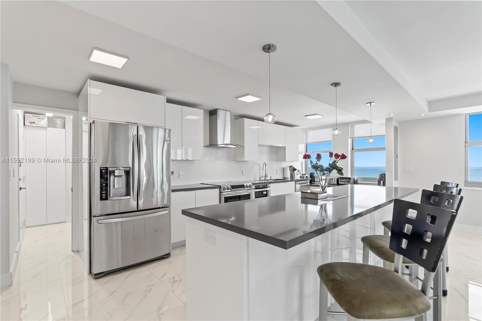 a kitchen with stainless steel appliances granite countertop a refrigerator a sink a stove and island