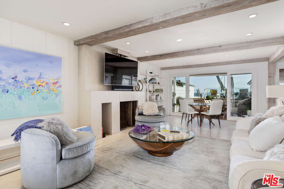 23626 Malibu Colony Road, Unit 53 Malibu, CA 90265 - Photo 11 of 24 a living room with furniture a fireplace and a flat screen tv
