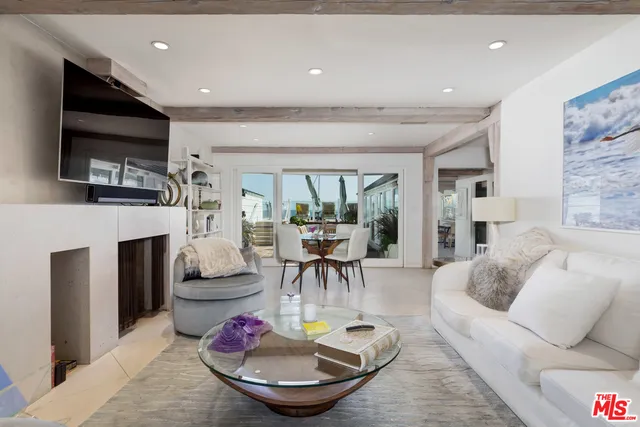 a living room with fireplace furniture and a large window