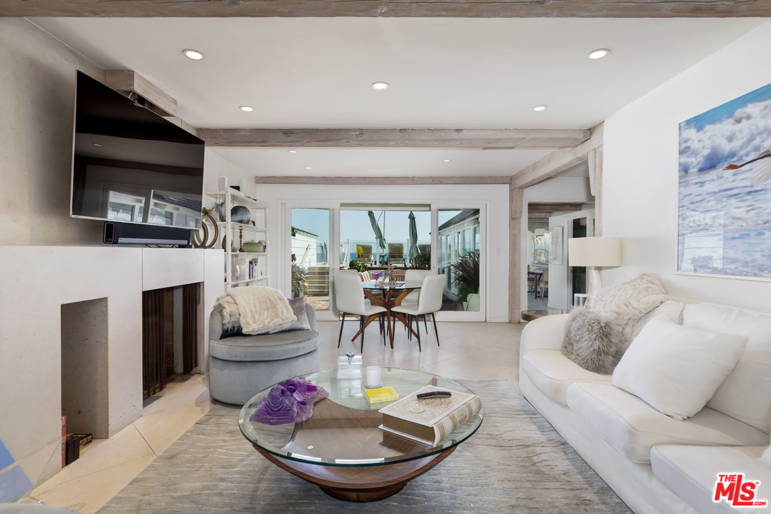 23626 Malibu Colony Road, Unit 53 Malibu, CA 90265 - Photo 12 of 24 a living room with fireplace furniture and a large window