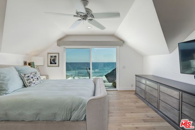 a bedroom with a large bed and a flat tv screen on dresser