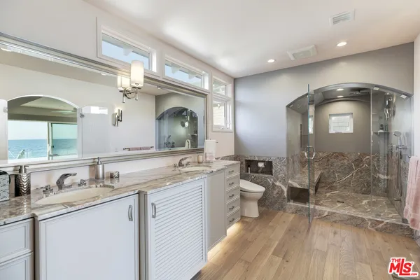a bathroom with a double vanity sink mirror and shower