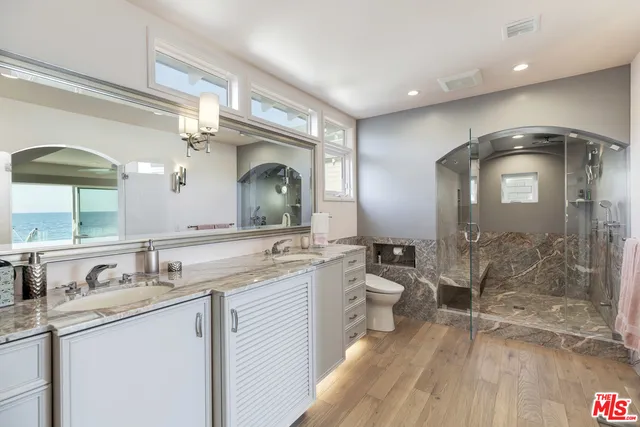a bathroom with a double vanity sink mirror and shower
