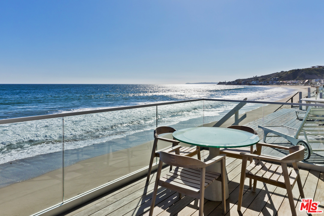 23626 Malibu Colony Road, Unit 53 Malibu, CA 90265 - Photo 3 of 24 a view of a swimming pool with a table and chairs
