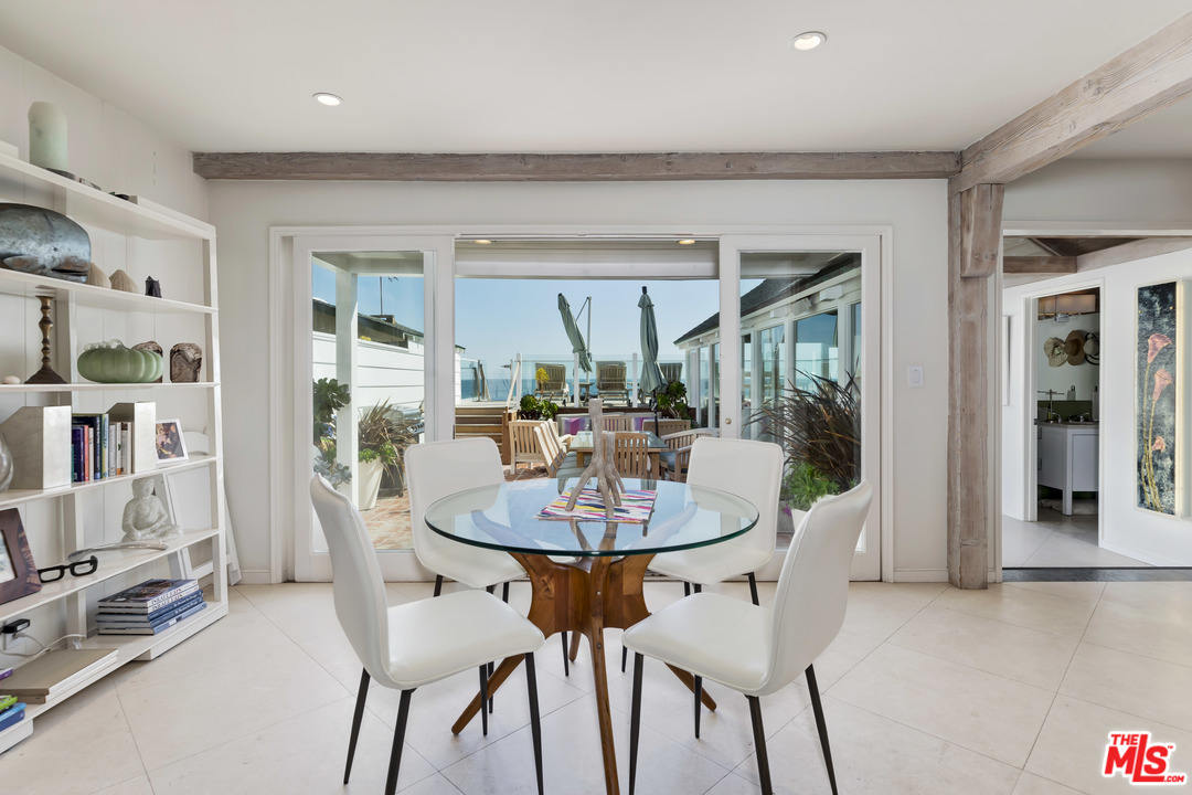 23626 Malibu Colony Road, Unit 53 Malibu, CA 90265 - Photo 10 of 24 a dining room with furniture and a floor to ceiling window
