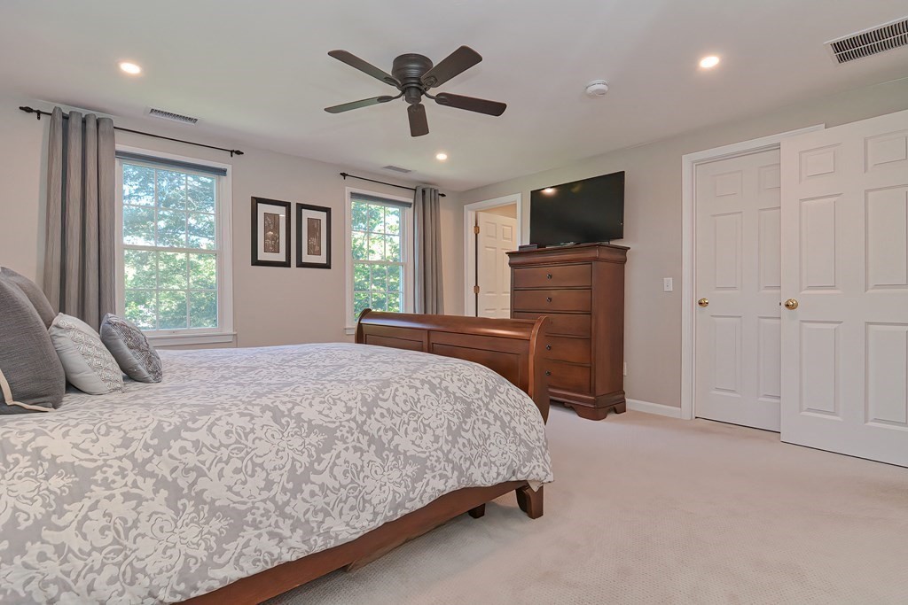 5 Tower Hill Drive Sandwich, MA 02563 - Photo 25 of 41 a bedroom with a large bed a flat tv screen and a chandelier