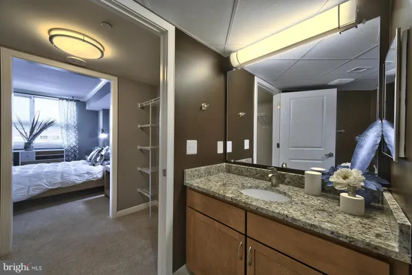 a en suite bathroom with a granite countertop sink and a mirror