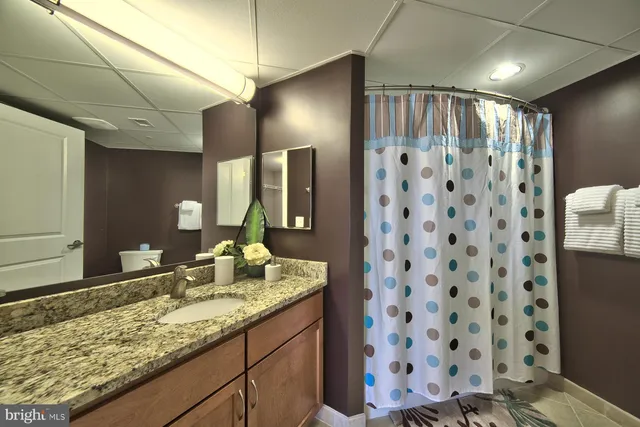 a bathroom with a granite countertop sink a toilet and shower