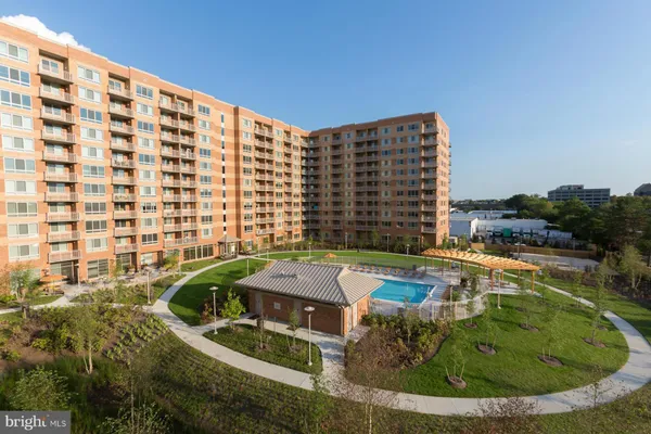 a view of swimming pool with outdoor seating and buildings in the background