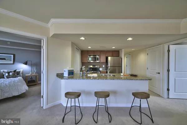 a kitchen with stainless steel appliances kitchen island a table and chairs in it