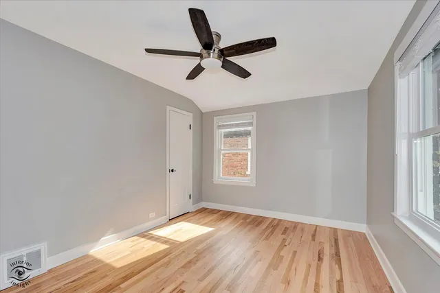 a view of empty room with wooden floor and window