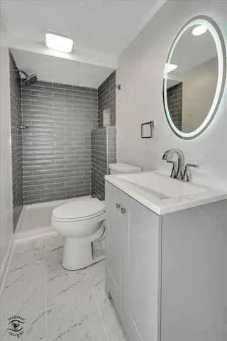 a bathroom with a toilet sink vanity and mirror