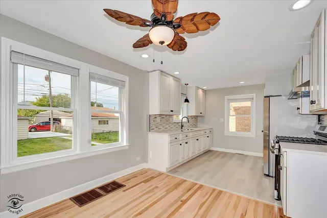 a open kitchen with stainless steel appliances granite countertop a stove and a wooden floors