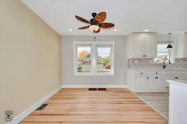 a very nice looking room with a large window wooden floor and a ceiling fan