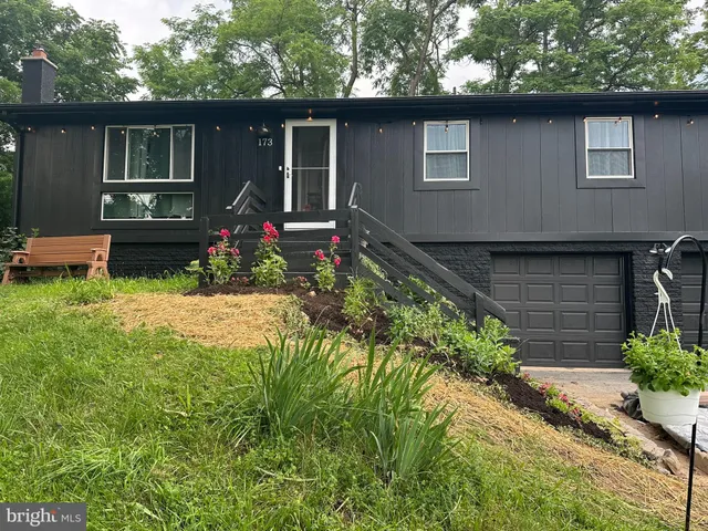 a front view of house with yard and trees around