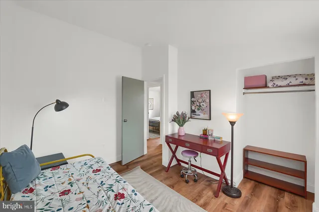 a bedroom with a bed and wooden floor