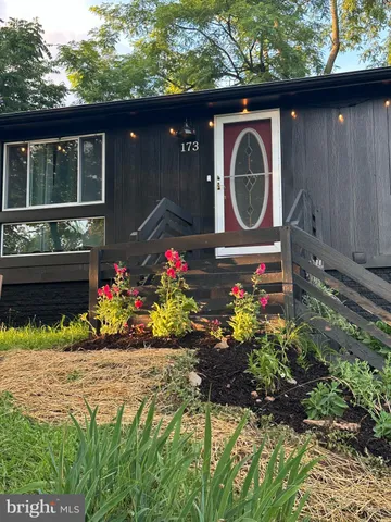a front view of a house with a yard and flowers