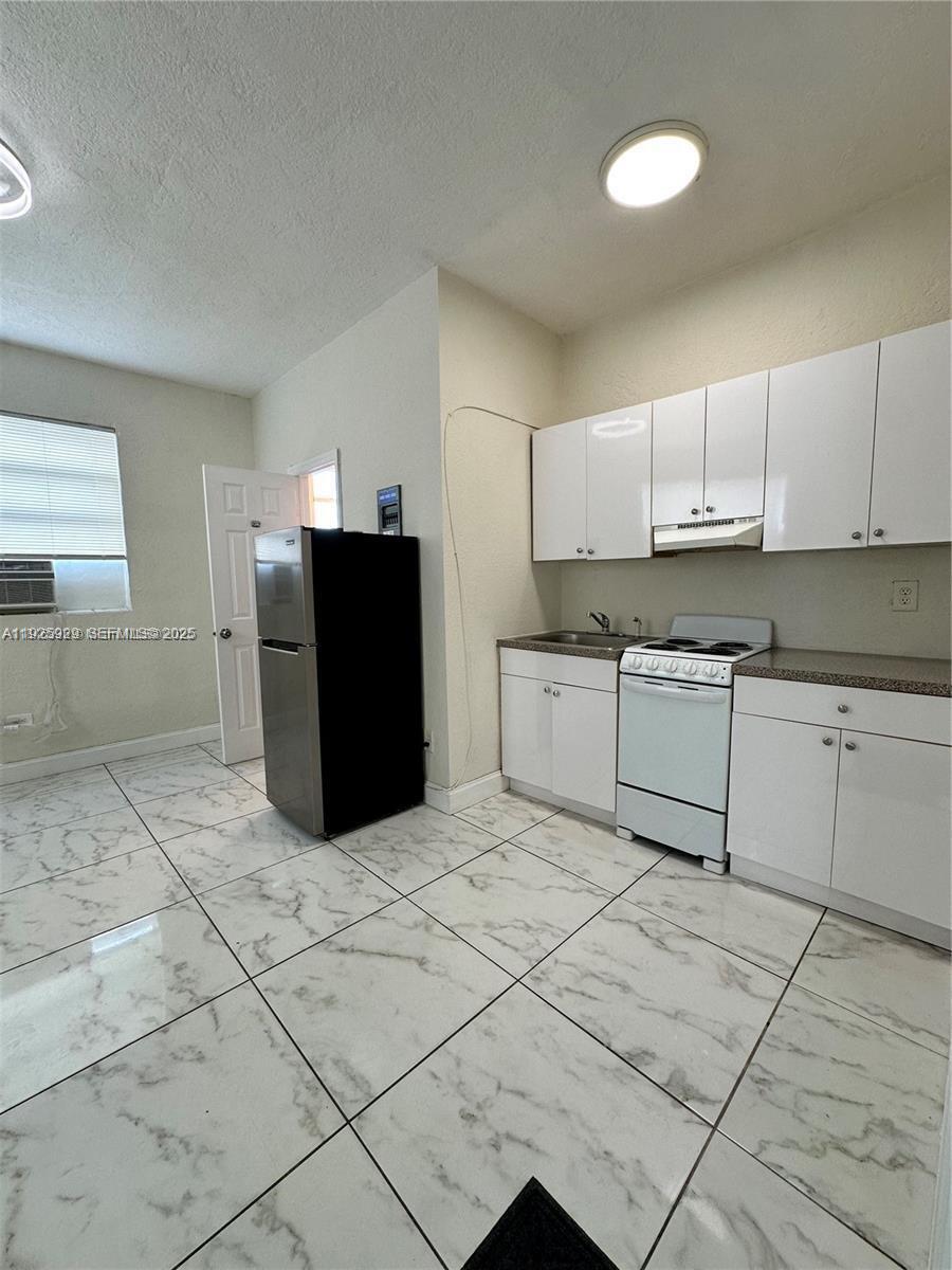 912 Northwest 9th Avenue, Unit 8 Hallandale Beach, FL 33009 - Photo 2 of 10 a kitchen with stainless steel appliances granite countertop a refrigerator sink and cabinets