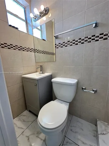 a bathroom with a granite countertop shower a toilet and sink