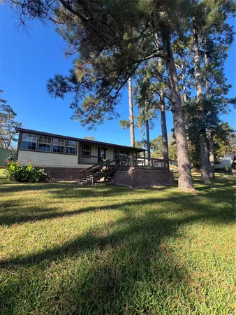 a view of a house with a big yard and a large tree