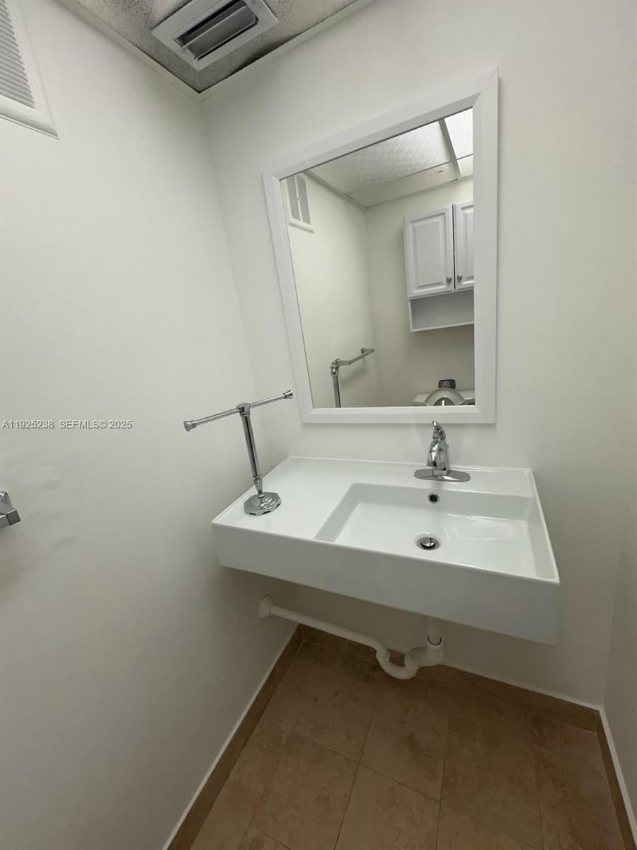 8101 Southwest 72nd Avenue, Unit 312W Miami, FL 33143 - Photo 8 of 19 a bathroom with a sink and a mirror