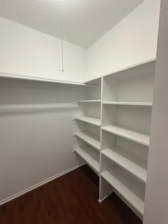 a view of walk in closet with empty racks