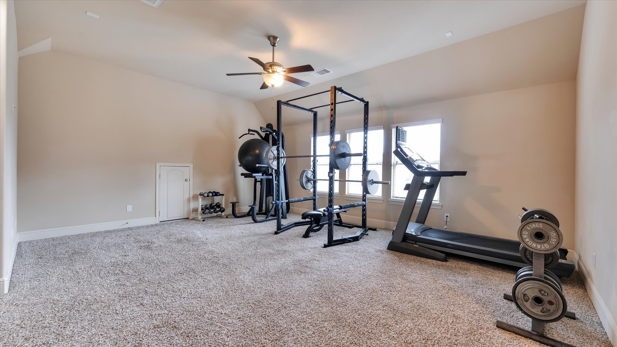 17211 Green Darter Conroe, TX 77385 - Photo 21 of 48 Upstairs there is a spacious game room currently being used as a home gym. Two windows provide natural light, and a ceiling fan ensures ventilation.