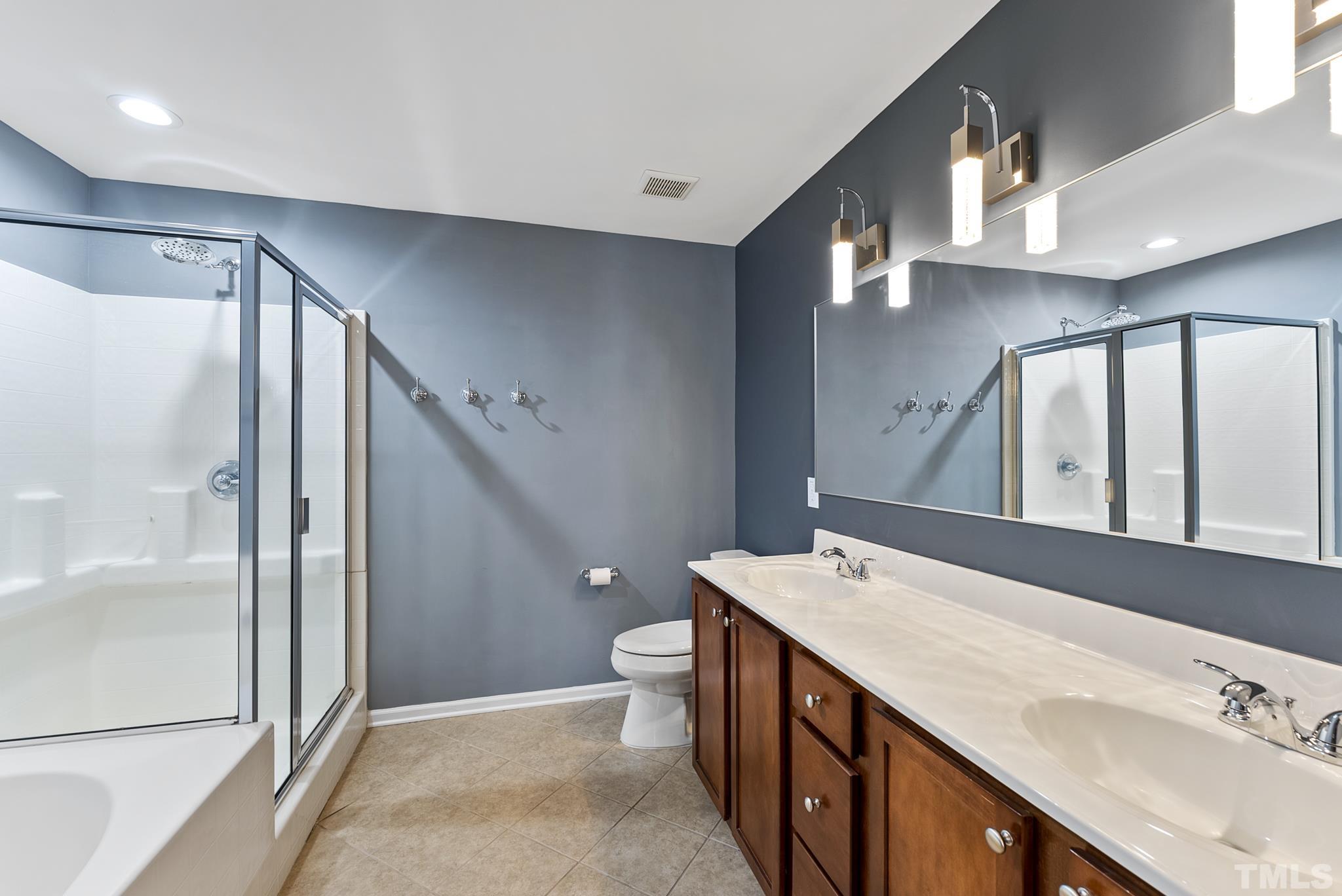 517 Dragby Lane Raleigh, NC 27603 - Photo 23 of 31 a spacious bathroom with a double vanity sink and a mirror