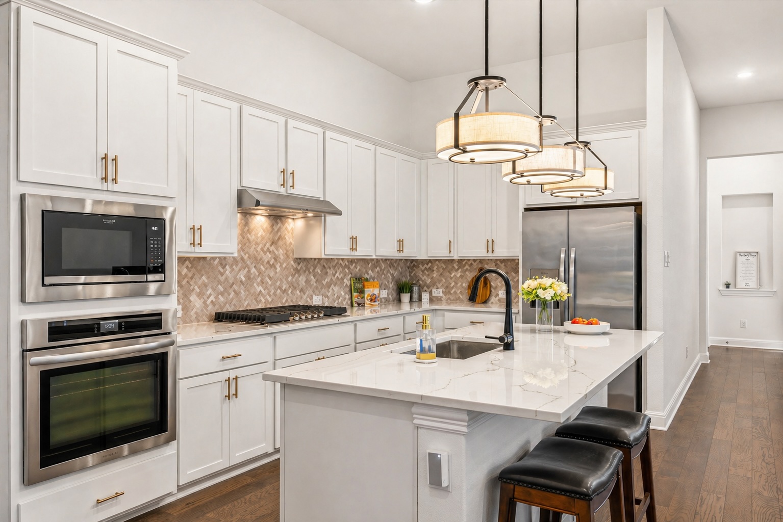 209 Rainier Drive Kyle, TX 78640 - Photo 10 of 24 Gourmet kitchen featuring white cabinetry, stainless steel appliances, herringbone tile backsplash, and an island with a waterfall-edge countertop