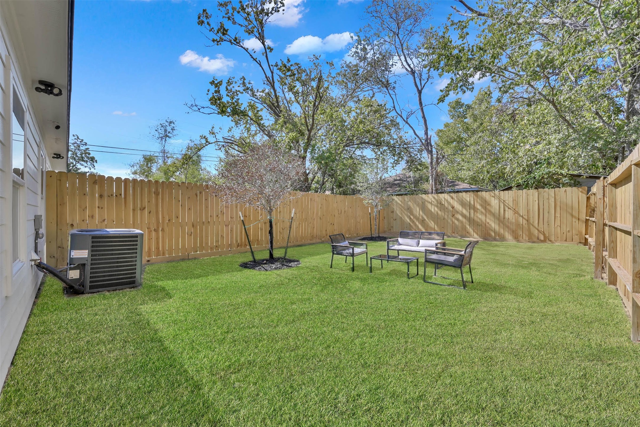 211 South 5th Street, Unit B Conroe, TX 77301 - Photo 12 of 14 a view of a backyard with table and chairs and a fire pit
